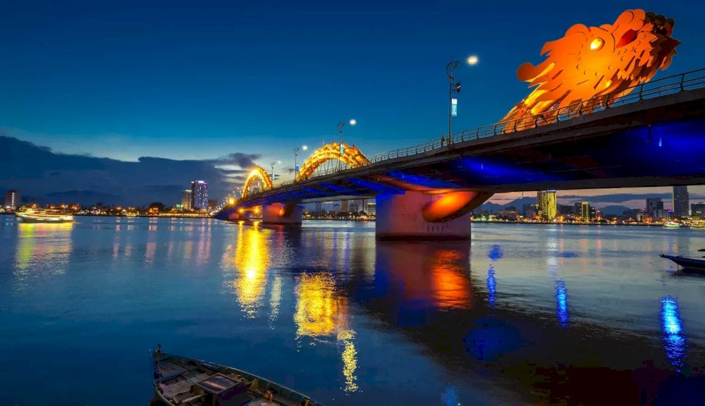 As night falls, the Dragon Bridge glows with an enchanting light